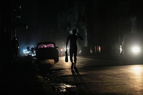A resident walks on a street during a general blackout in Havana, Cuba, Friday, March 14, 2025.