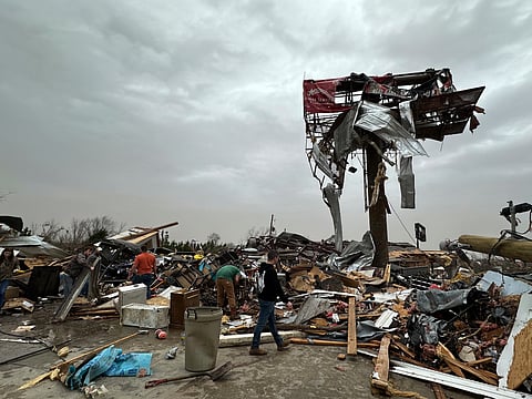 People work through the debris of the Cave City Auto Parts store on Saturday, March 15, 2025 after a severe weather storm Friday night in Cave City, Arkansas.