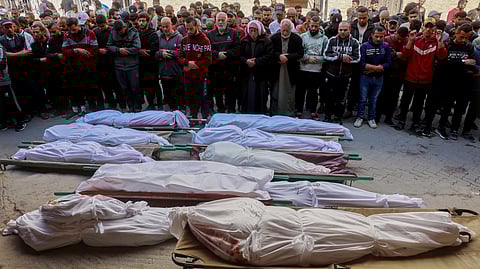 Palestinian mourners pray over the bodies of victims of overnight Israeli airstrikes on the Gaza Strip at Al-Ahli Arab hospital, also known as the Baptist hospital, in Gaza City ahead of their burial on March 18, 2025.