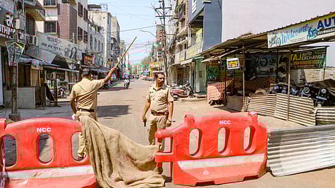 Police personnel stand guard at Chitnis Park area amid curfew after violence erupted on Monday night, in Nagpur, Tuesday, March 18, 2025.