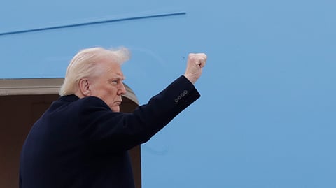 President Donald Trump gestures from the stairs of Air Force One at Joint Base Andrews, Md., Friday, March 14, 2025.