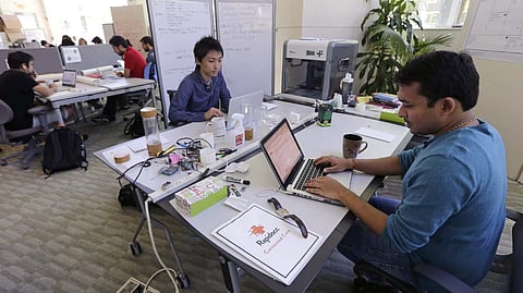 In this photo from June 30, 2016, Babson College graduate school alumnus Abhinav Sureka, of Mumbai, at right, typing at a workspace at the Wellesley, Mass.