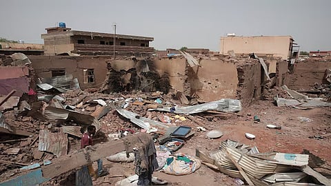 A man walks by a destroyed house in Khartoum, Sudan, an area torn by fighting between the military and the notorious paramilitary Rapid Support Forces, on April 25, 2023.