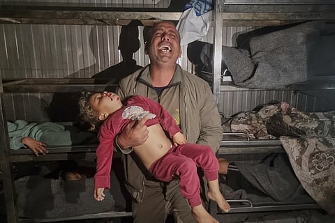 Eyad Abu Jazar holds the body of a child he believes to be his nephew, who was killed in Israeli army airstrikes, at Nasser hospital morgue in Khan Younis, southern Gaza Strip, March 18, 2025.
