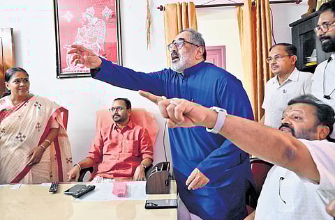 Former Union minister Rajeev Chandrasekhar and Union Minister Suresh Gopi request a chair for party leader Sobha Surendran, who arrived late to the meeting at the BJP state headquarters in Thiruvananthapuram on Sunday.