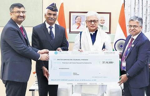Rajesh Kumar, CGM SBI, hands over the cheque to Governor Jishnu Dev Varma in Hyderabad on Tuesday. The Governor is the chairperson of the Armed Forces Flag Day Fund.
