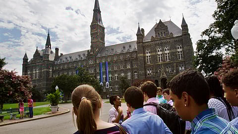 FILE - In this July 10, 2013, file photo, prospective students tour Georgetown University's campus in Washington.