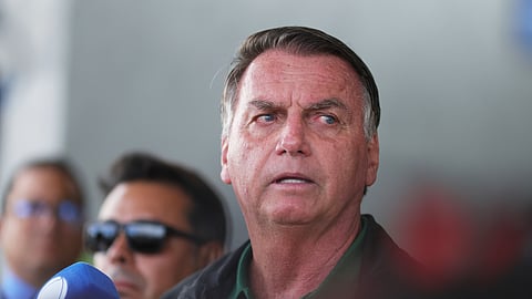 Brazil's former President Jair Bolsonaro speaks to the press as he arrives at the Brasilia International Airport in Brasilia, Brazil, Tuesday, March 25, 2025.