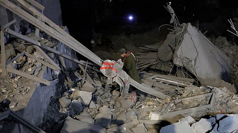 A Yemeni walks on debris from a destroyed building after it was struck by U.S. airstrikes in Sanaa, Yemen, Monday, March 24.
