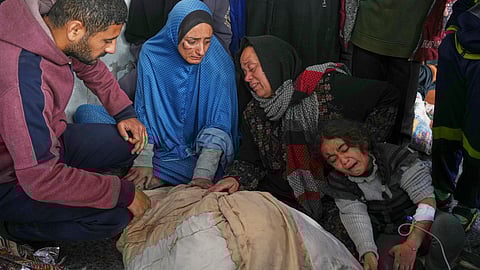 Members of the Al-Kahlout family mourn over the bodies of their relatives killed during an Israeli army strike before their burial at the Baptist hospital in Gaza City, Monday, March 24, 2025.