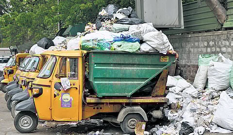 Auto tippers and garbage trucks piled with waste, parked on Dickenson Road in Bengaluru on Wednesday