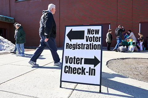 A sign for new voter registration is seen outside a polling location at Pinkerton Academy in Derry, N.H., Tuesday, March 11, 2025.