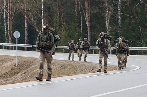 Lithuanian soldiers patrol on a road near a training range in Pabrade, north of the capital Vilnius, Lithuania on Thursday, March 27, 2025.