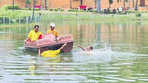 Fire services personnel searching for the lost mobile phone in the pond of Biju Patnaik park at Berhampur on Thursday.