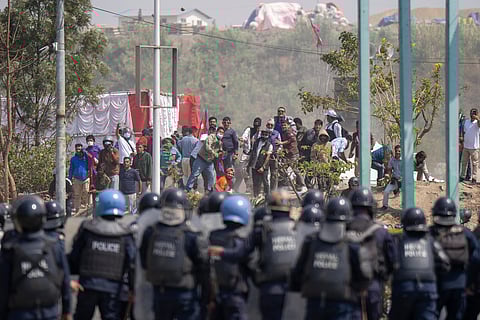 Members of a pro-monarchist group hurls stones at police officers during a protest in Kathmandu, Nepal, on Friday, March 28, 2025.