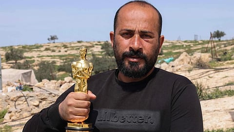 Palestinian filmmaker and Oscar winner for the documentary "No Other Land" Hamdan Ballal poses for a picture with his Oscar, as he recovers after Israeli settlers attacked him at home, in his village of Susya in the south of the occupied West Bank on March 26, 2025.