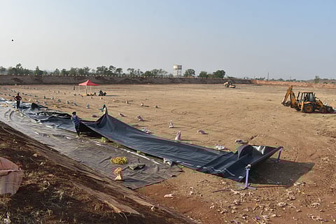 Workers engaged in restoration work of a dormant lagoon, which is being revamped to serve as a water reservoir.