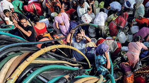 People draw water from a tanker in the city.