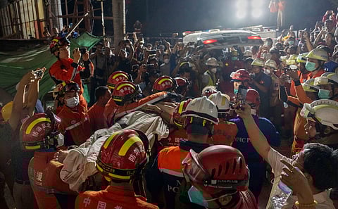 In this photo released by Xinhua News Agency, members of a China search and rescue team transfer a survivor from a collapsed Great Wall Hotel in the aftermath of an earthquake in Mandalay, Myanmar, Monday, March 31, 2025.
