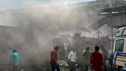 People gather at the site after a blast at a firecracker warehouse led to a blaze and collapse of the building, in Gujarat's Banaskantha district, Tuesday, April 1, 2025.