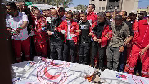 Mourners gather around the bodies of 8 Red Crescent emergency responders, recovered in Rafah a week after an Israeli attack, as they are transported for burial from a hospital in Deir al-Balah, Gaza Strip, on Monday, March 31, 2025