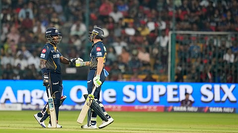 Gujarat Titans' Sherfane Rutherford, left, and batting partner Jos Butler touch gloves during the Indian Premier League cricket match between Gujarat Titans and Royal Challengers Bengaluru at Chinnaswamy Stadium in Bengaluru, India, Wednesday, April 2, 2025.