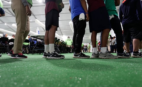 Immigrants line up in the dining hall at a U.S. government holding center for migrant children, July 9, 2019, in Carrizo Springs, Texas.