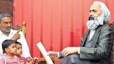 Attendees taking pictures with a Karl Marx statue