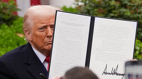 President Donald Trump holds a signed executive order during an event to announce new tariffs in the Rose Garden of the White House, Wednesday, April 2, 2025, in Washington.