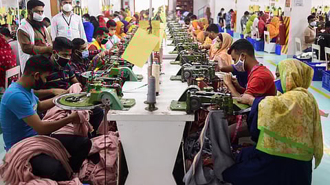 In this picture taken on March 15, 2021, people work in a garment factory in Gazipur, Bangladesh.