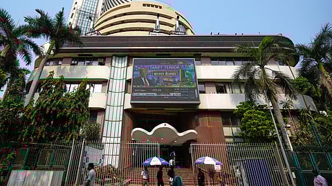 People watch the stock market index on a display screen on the facade of the Bombay Stock Exchange (BSE) building in Mumbai.