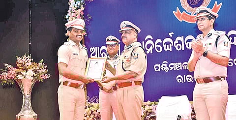 The DGP awarding a policeman in recognition of his service on Friday