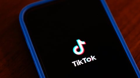 The TikTok app logo is shown on an iPhone.