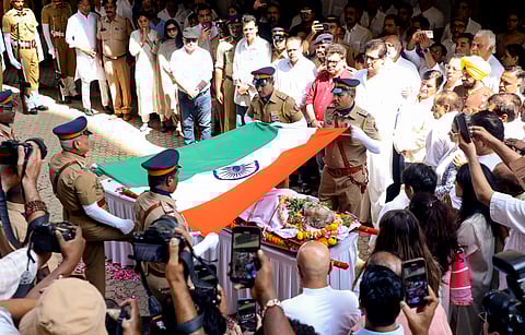 Police personnel wrap the mortal remains of veteran actor-filmmaker Manoj Kumar during his last rites