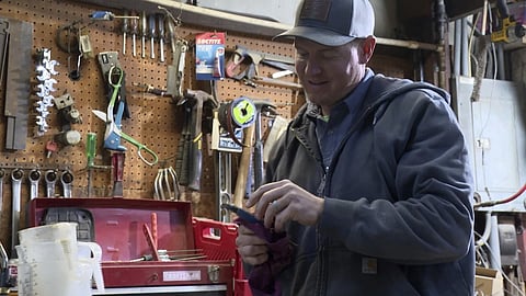 Bryant Kagay holds a tool in the workshop of the farm he co-owns with his father and grandfather in Amity, Missouri, Friday, April 4, 2025