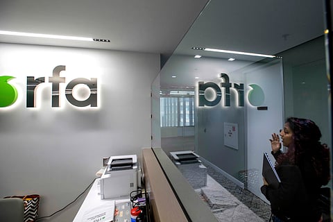 A woman walks past the empty receptionist desk at Radio Free Asia, Tuesday, April 1, 2025, in Washington.