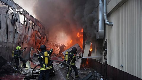 In this photo provided by the Ukrainian Emergency Service, emergency services personnel work to extinguish a fire following a Russian missile attack in Kyiv, Ukraine, Sunday, April 6, 2025.