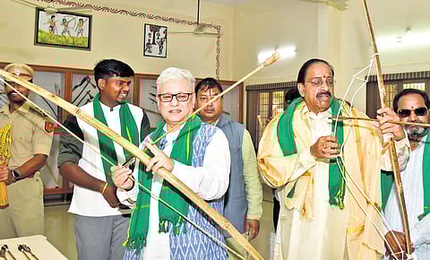 Governor Jishnu Dev Varma tries his hand at bow and arrow at tribal museum.