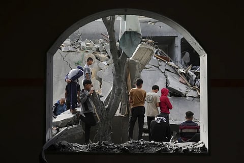 Palestinians inspect the site hit by an Israeli airstrike in Deir Al-Balah Gaza Strip on Monday, April 7, 2025.