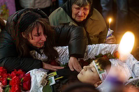 A mother cries at the coffin of her son Herman Tripolets, 9, killed by a Russian missile, during a funeral ceremony in Kryvyi Rih, Ukraine, Monday, April 7, 2025.