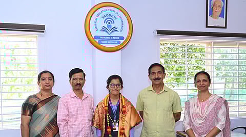 Deeksha R with her parents and the college staff.