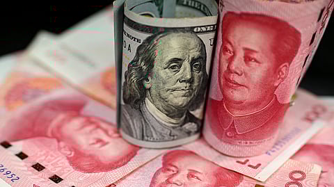 This photo shows Chinese 100 yuan notes and US 100 dollar bills, in Beijing, on April 8, 2025, amid the ongoing trade war between China and the US.