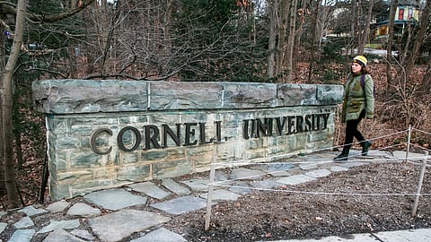 A woman walks by a Cornell University sign on the Ivy League school's campus in Ithaca, New York, on Friday, Jan. 14, 2022.