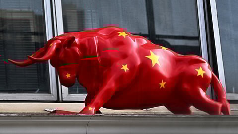 A sculpture of a bull decorated in the Chinese flag is seen above a securities exchange in Hong Kong.
