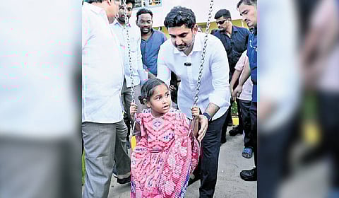 HRD Minister Nara Lokesh swings a girl at the SLN Park in Mangalagiri.