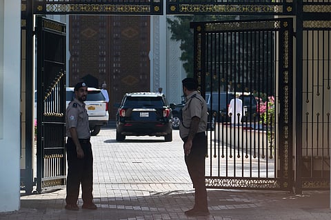 Omani security personnel watch a convoy believed to be carrying U.S. Mideast envoy Steve Witkoff in Muscat, Oman, Saturday, April 12, 2025.