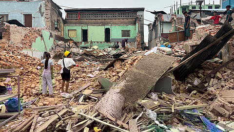 In this photo from April 7, 2025, people clean debris from damaged buildings in the aftermath of an earthquake on March 28 in Naypyitaw, Myanmar.