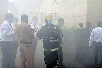 Firefighters and officials monitor the situation outside Park Hyatt on Monday