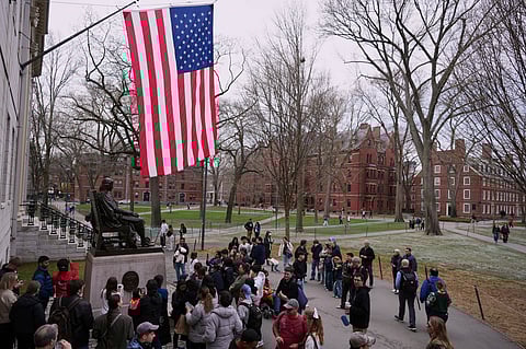 Visitors stop at the statue of John Harvard in Harvard Yard at Harvard University, Tuesday, April 15, 2025, in Cambridge, Mass.