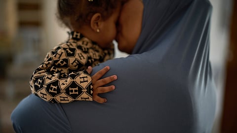 A 52-year-old family matriarch, who did not want to be named for fear of reprisal, kisses a granddaughter in a wedding hall at a charity center that has been used as a temporary shelter for displaced people in the West Bank town of Anabta.